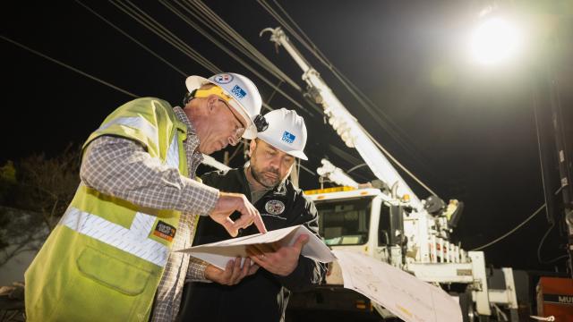 dos empleados de LADWP revisando papeleo en el lugar de trabajo durante la noche