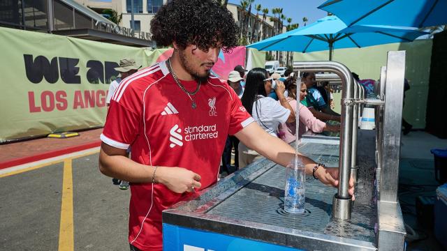 person filling up water bottle at event