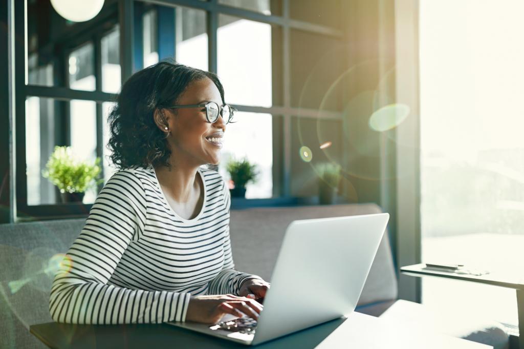 woman sitting in front of laptop with sun shining on her