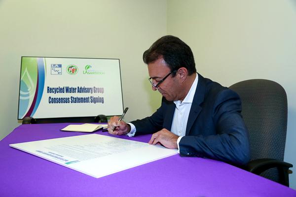 Photo of David Nahai signing document