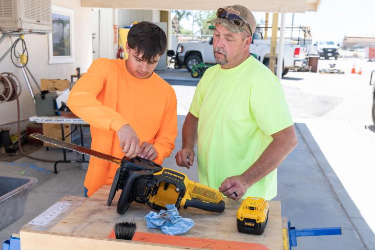 Community Partnerships Image for LADWP in the Eastern Sierra - Two people working on chainsaw