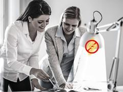 two woman at a desk with lamp shining down