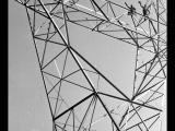 Upward view of workers atop power transmission tower