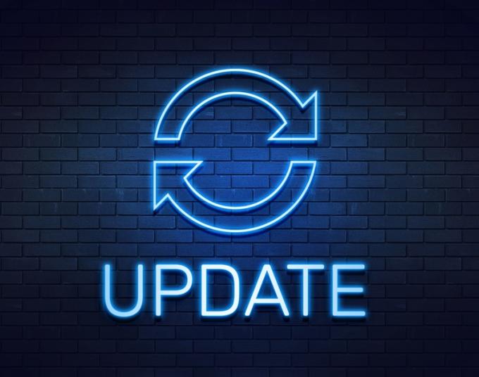 A neon light in the shape of the “update” icon is shown against a brick wall, with the word UPDATE below.