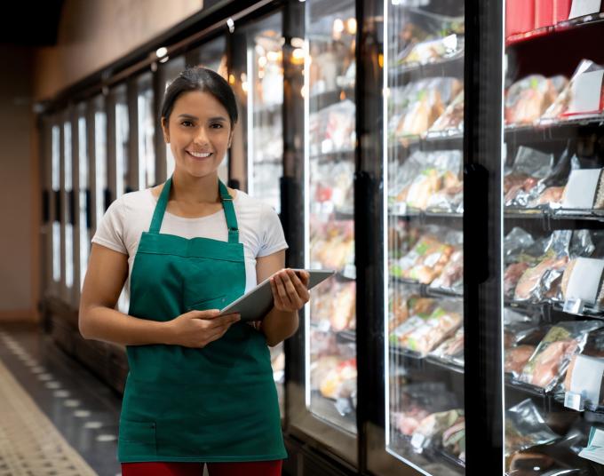 Woman standing next to freezer section